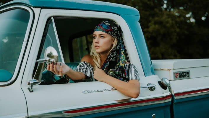 Woman Adjusting Car Mirror