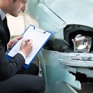Insurance Adjuster Looking at Car After a Collision